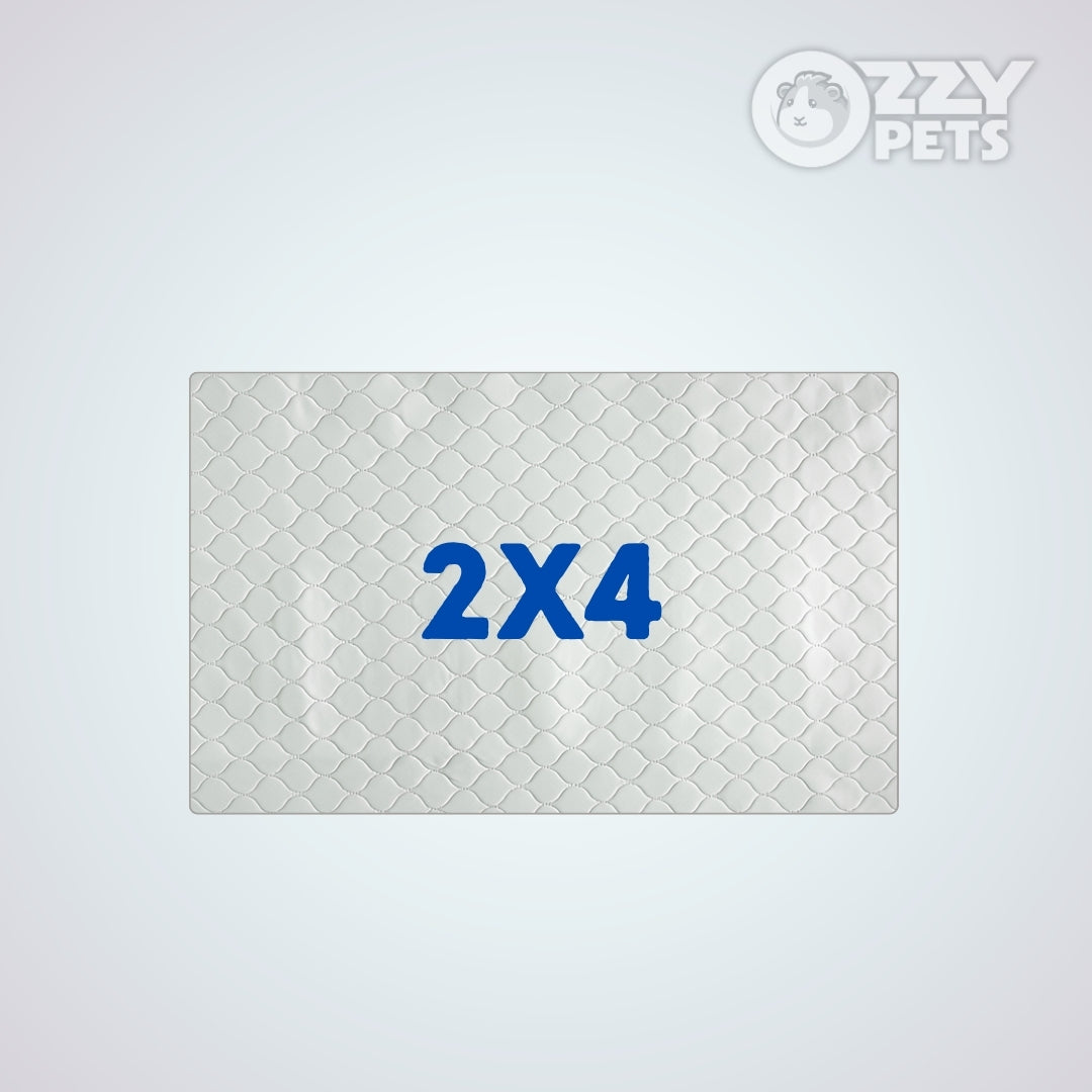 A rectangular white quilted pet mat with a diamond pattern and the blue text '2X4' in the center, shown on a light gray background with the 'OZZY PETS' logo in the top right corner.